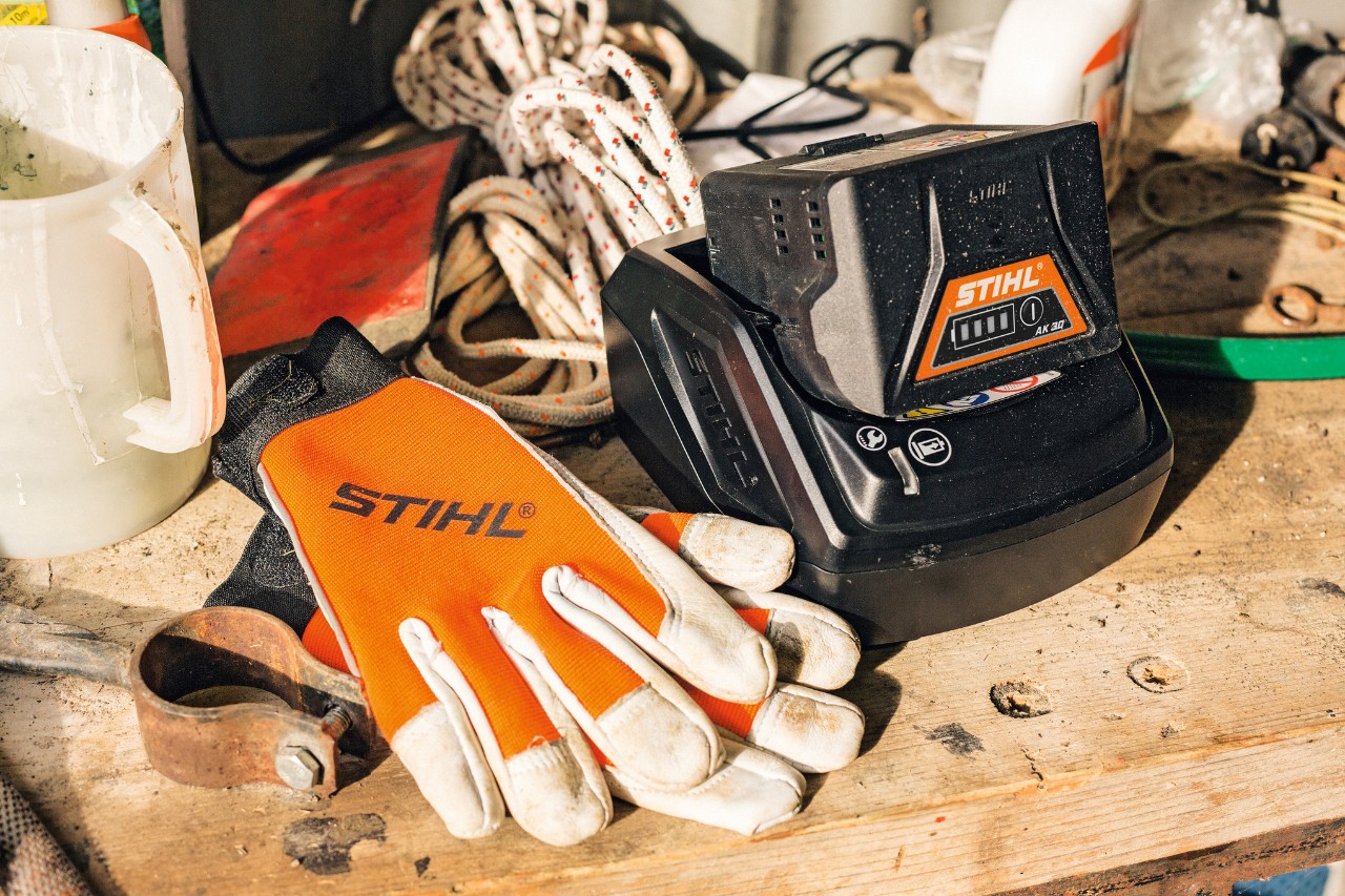 Battery and gloves lying on a work surface