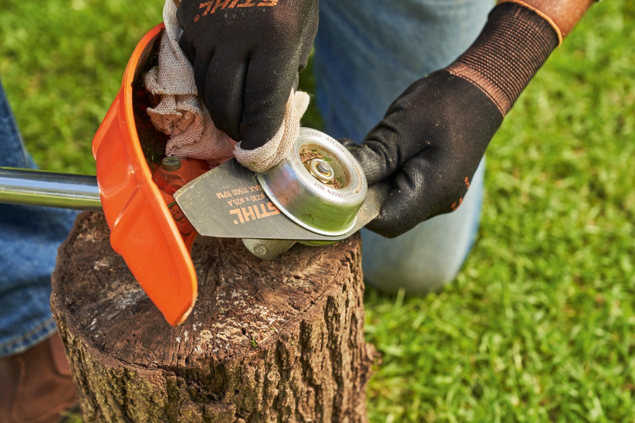 Cleaning a brush knife on a STIHL brushcutter with a damp cloth
