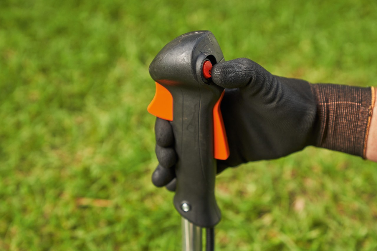A man switching off a STIHL FS 56 petrol brushcutter