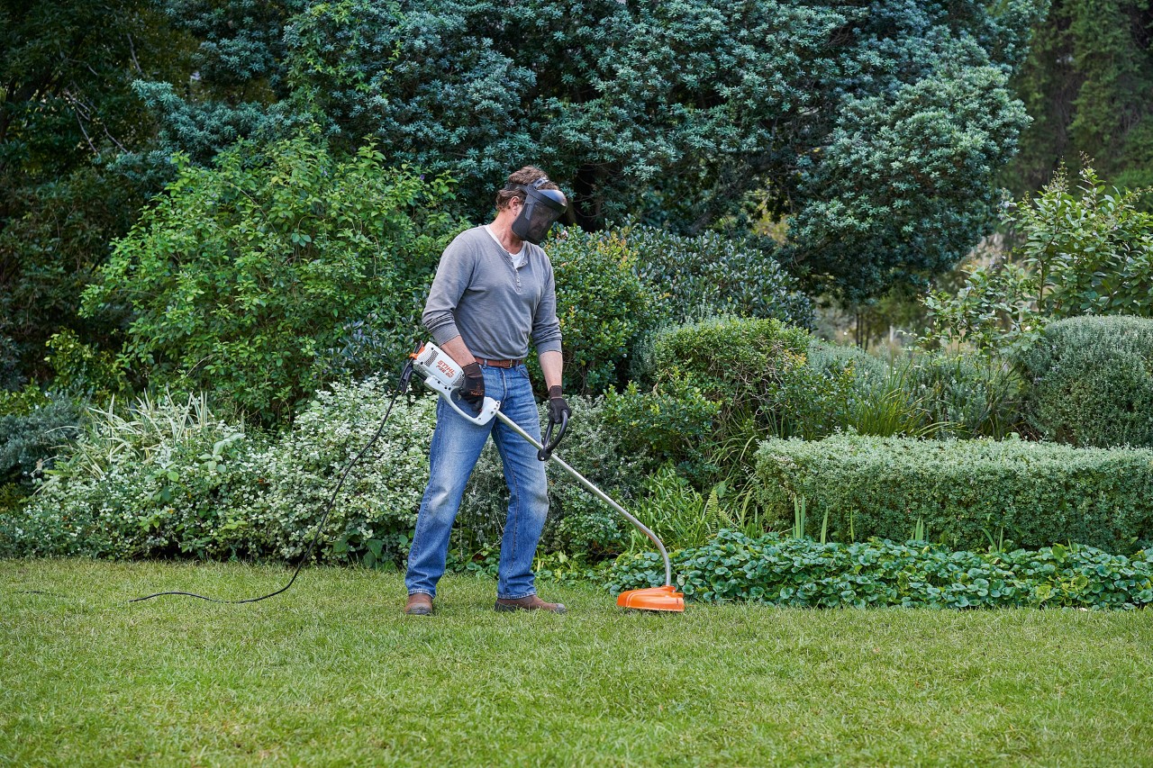 A man with a STIHL FSE 60 electric brushcutter taking a secure stance on his feet